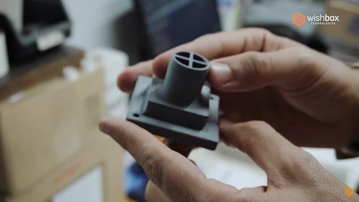 Peça industrial impressa em 3D nas mãos de uma pessoa.