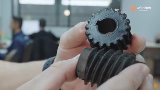 Peça industrial impressa em 3D nas mãos de uma pessoa.